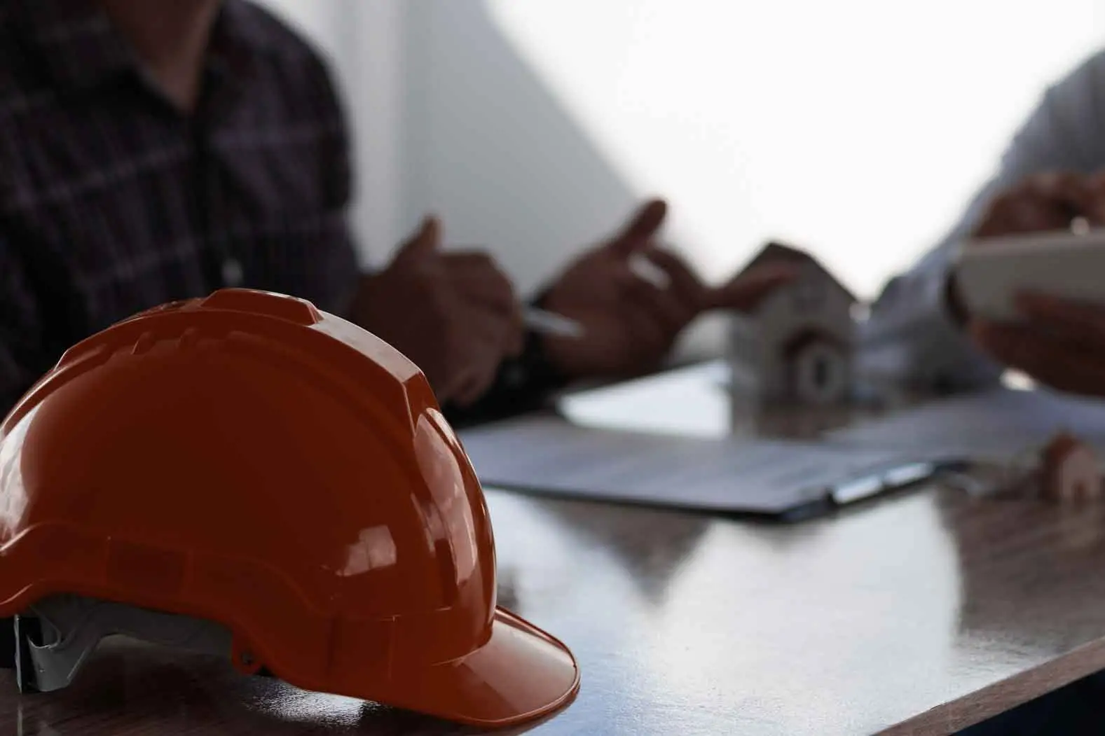 Baustellenplanung mit Schutzhelm und Bauunterlagen für professionellen Arbeitnehmerschutz in Graz und der Steiermark.